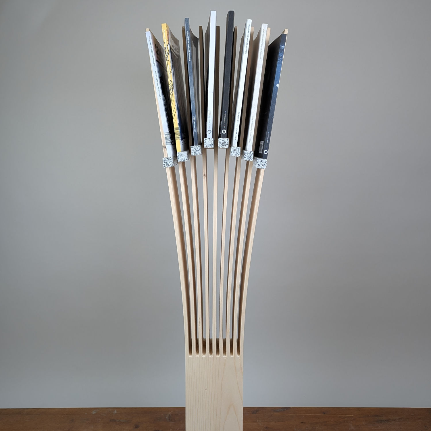 Three-quarter view of the Media Slate stand highlighting its versatility as a sculptural holder for magazines, records, and media.