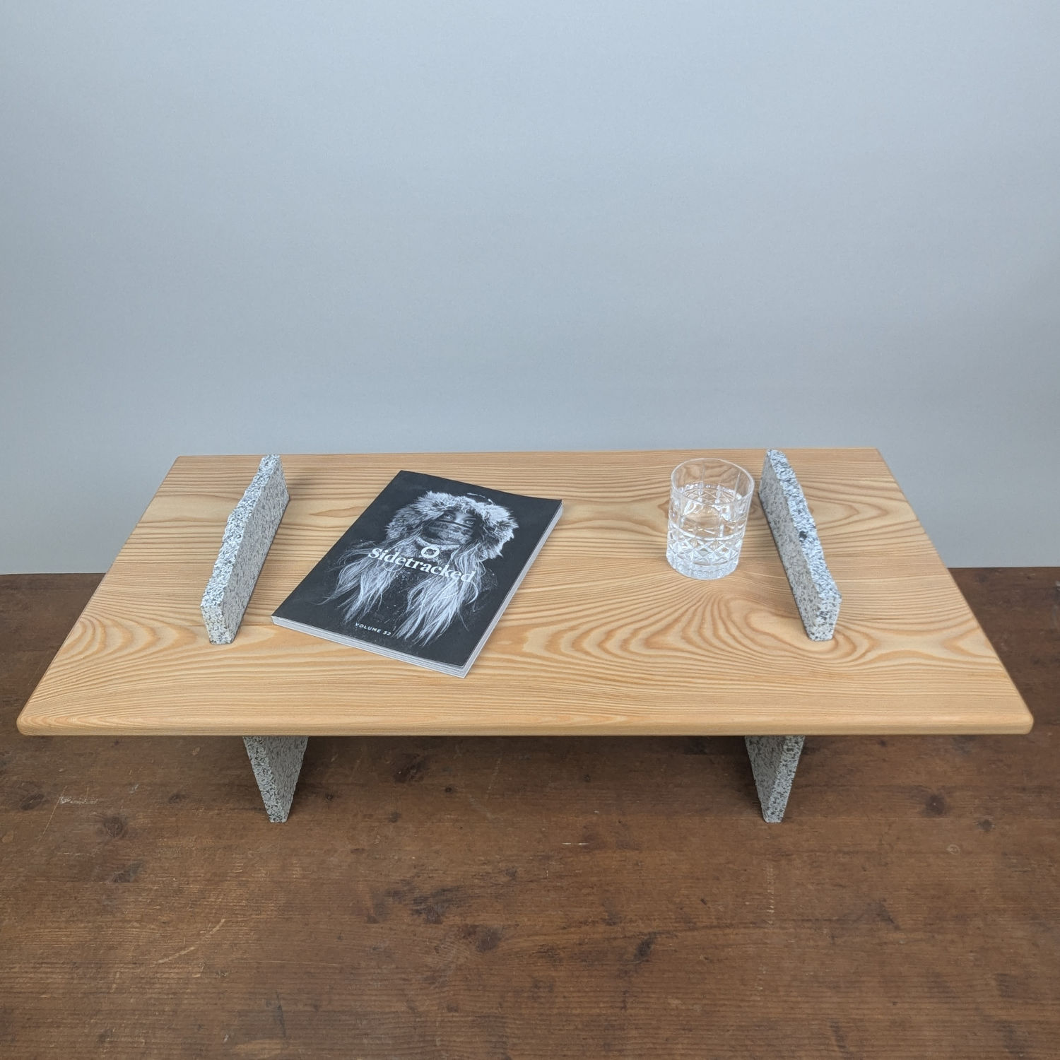 Stone Stage coffee table with a solid oak top supported by hand-sculpted granite legs.