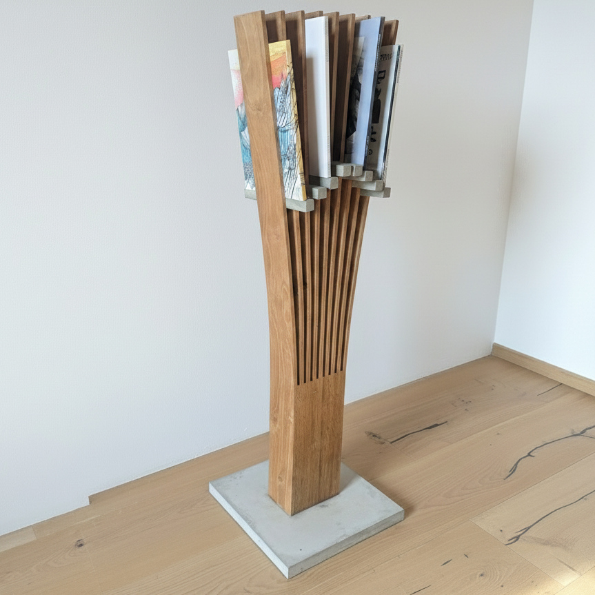 Portariviste scultoreo da terra realizzato con doghe verticali in rovere, distanziatori in cemento personalizzati per sorreggere le riviste e una base in cemento massiccio.